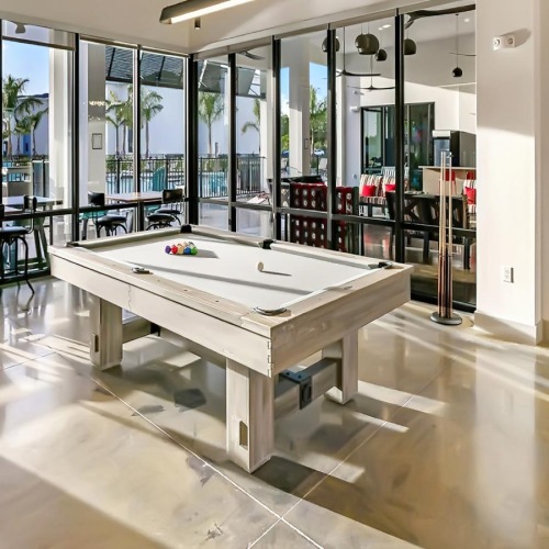 a room with a pool table and chairs